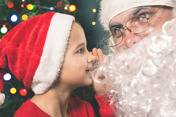 Santa and boy near the decorated Christmas tree. Wishes list - Фото, изображение