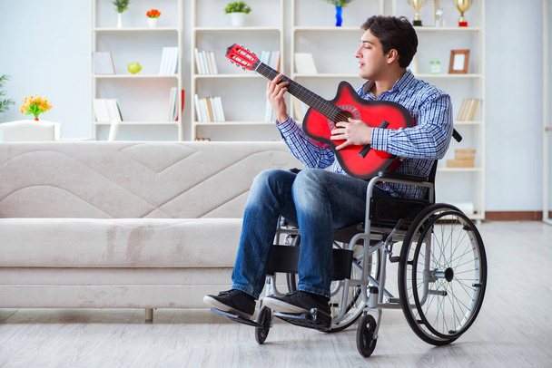 Hombre discapacitado tocando la guitarra en casa - Foto, Imagen