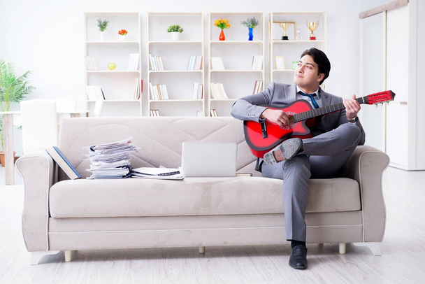 Бизнесмен играет на гитаре дома - Фото, изображение
