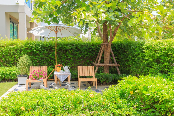 Thee set op houten tafel onder witte paraplu in de tuin in su - Foto, afbeelding
