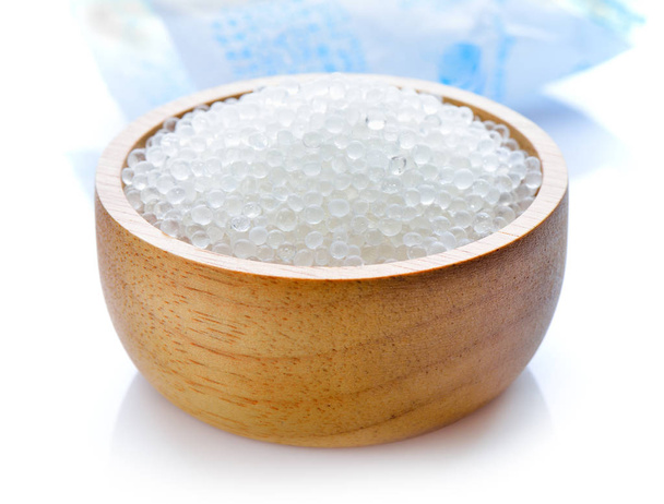 Silica gel σε ξύλινο μπολ σε λευκό φόντο - Φωτογραφία, εικόνα