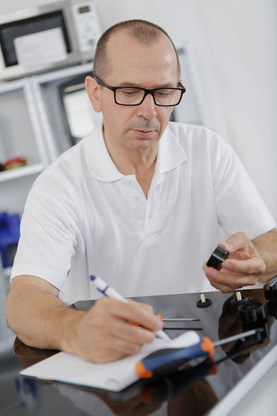 appliance technician writing his notes - Foto, imagen