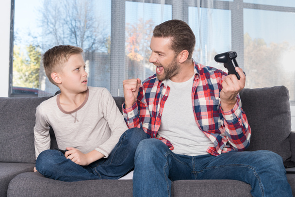 father and son playing with joysticks - Valokuva, kuva