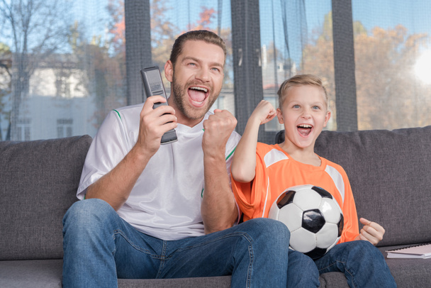 apa és fia nézi labdarúgó mérkőzés - Fotó, kép