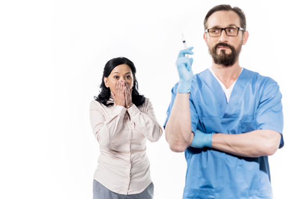 paciente asustado y médico con jeringa
 - Foto, Imagen
