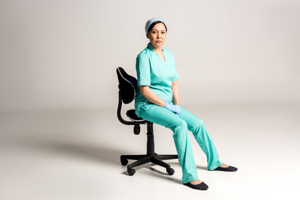 asian doctor sitting on chair - Фото, изображение