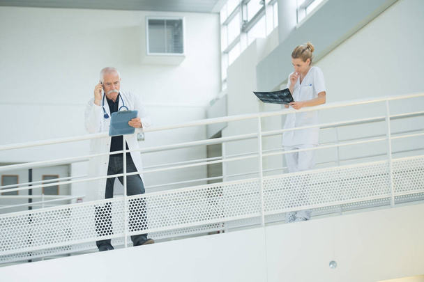 senior doctor and nurse at hospital corridor - Фото, изображение