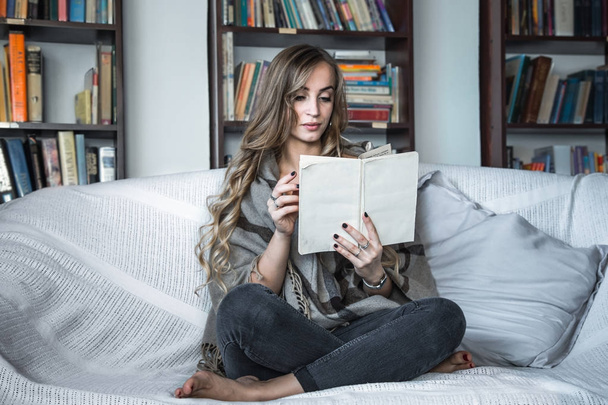 girl reading book on sofa - Фото, изображение