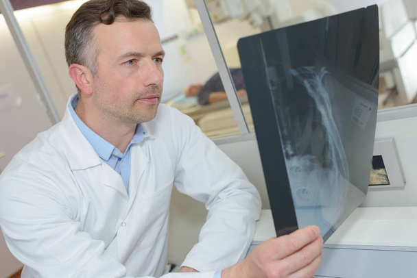 врач-взрослый мужчина ищет рентген
 - Фото, изображение