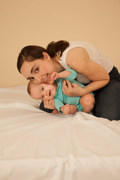 Mother with baby playing in bed - Photo, Image