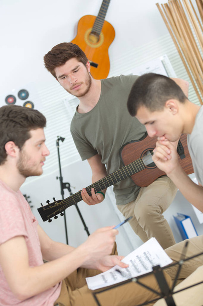 male friends playing acoustic guitar and sing at home - Zdjęcie, obraz