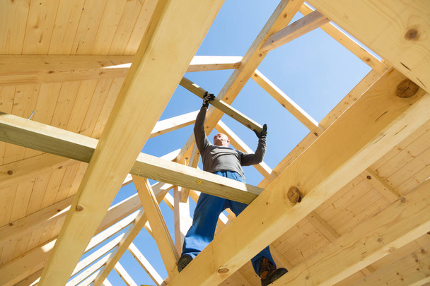 Bauarbeiter bei der Arbeit mit Holzdachkonstruktion. - Foto, Bild
