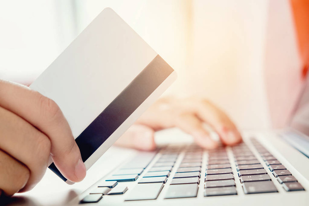 Woman shopping online using laptop with credit card enjoying in  - Fotó, kép