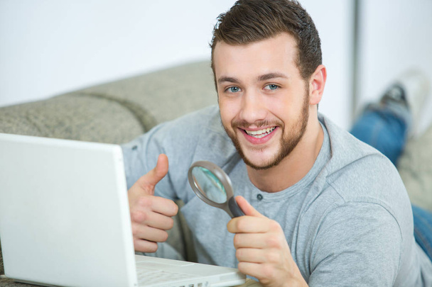 man work on laptop with magnifying glass - Fotografie, Obrázek