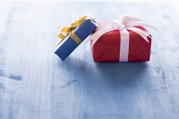 Dos cajas de regalo sobre mesa azul
 - Foto, Imagen