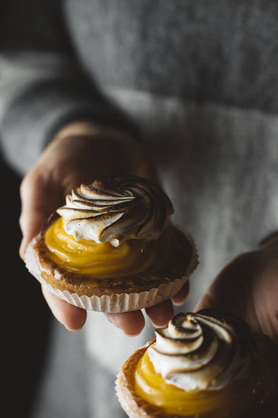 Zitronenkuchen in Frauenhand. traditionelle französische Süßgebäcktorte. lecker, appetitlich, hausgemachtes Dessert mit Zitronencreme. Kopierraum, Nahaufnahme. Selektiver Fokus. gemildert - Foto, Bild