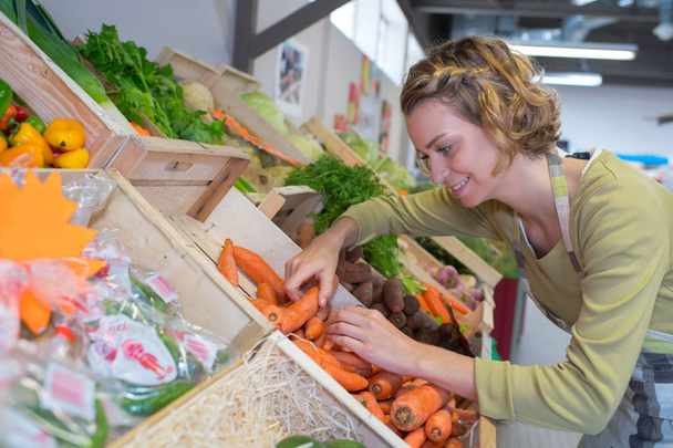 donna che lavora nella sezione verdure in un mercato
 - Foto, immagini