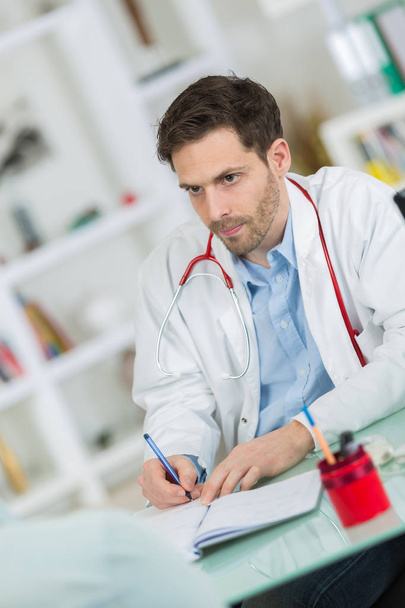 medical physician doctor listening to patient and taking notes - Foto, Bild