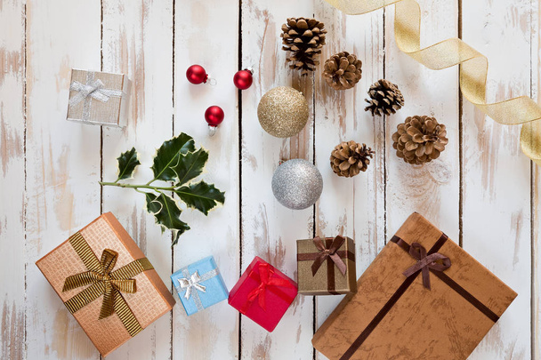 Christmas presents and decorations over a rustic wooden table - Fotó, kép