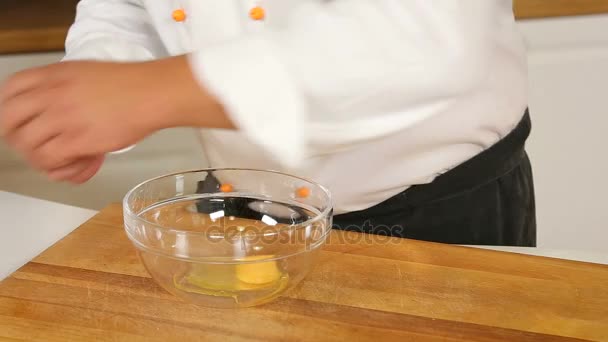 Cracking and whisking eggs in a glass bowl - Filmati, video