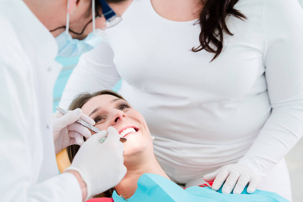 Patient vom Zahnarzt in seiner Praxis behandelt - Foto, Bild