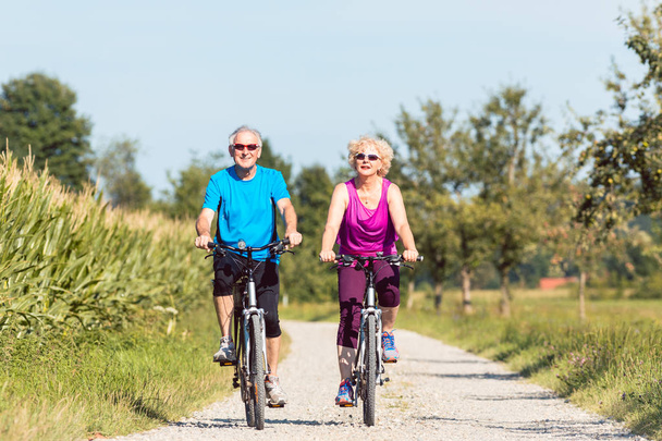 Active senior couple enjoying retirement while riding bicycles i - Zdjęcie, obraz
