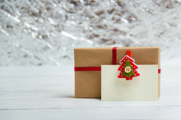 Vintage gift box package with blank gift tag on white wooden background - 写真・画像