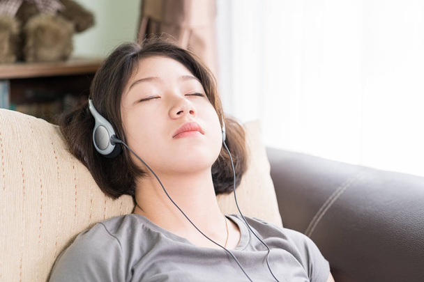 Молода жінка слухає музику з мобільного телефону
 - Фото, зображення
