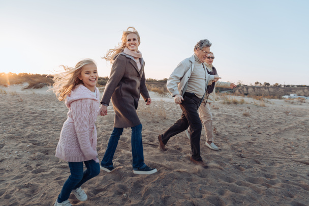 intergenerationele familie wandelen op strand - Foto, afbeelding