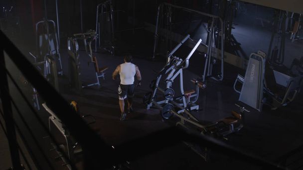 Sportler Sportler Bodybuilder trainiert in der Turnhalle. schöner muskulöser Sportler im Fitnessclub, von oben gesehen. Kämpfer - Foto, Bild