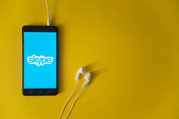 Skype logo on smartphone screen on yellow background - Foto, imagen