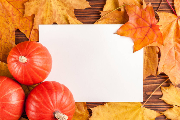 Jesień poziomy baner z żółtymi liśćmi, pomarańczowe dynie na drewnianym teksturowanej tło. - Zdjęcie, obraz