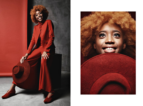 Diptych of beautiful young black smiling woman with red hair wearing red wide pants, jacket, sweater and shoes sitting in studio with grey and red background and holding red hat - Fotografie, Obrázek