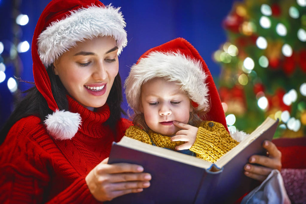 mother reading a book at Christmas - Zdjęcie, obraz