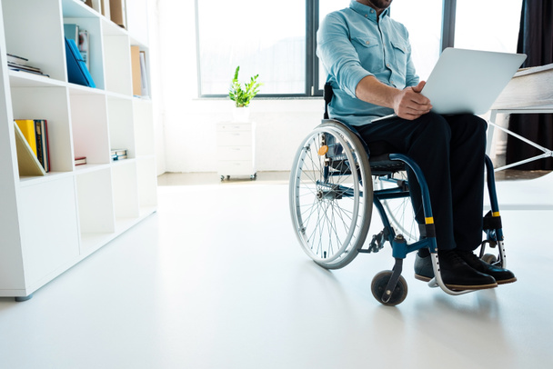 бизнесмен в инвалидной коляске с помощью ноутбука
 - Фото, изображение