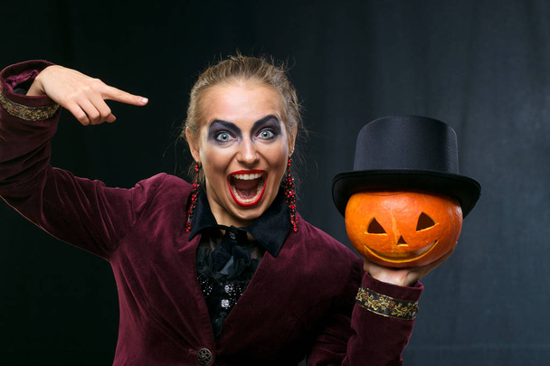 cheerful girl witch on Halloween with pumpkin. - Photo, image