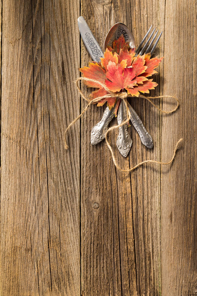 Local de jantar de outono cenário para feriado de Ação de Graças com folhas de bordo coloridas em tábuas de madeira rústica
 - Foto, Imagem