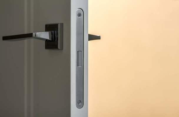 Современная металлическая ручка на белой двери крупным планом - Фото, изображение