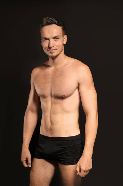 Young man in underwear on black background - Photo, image
