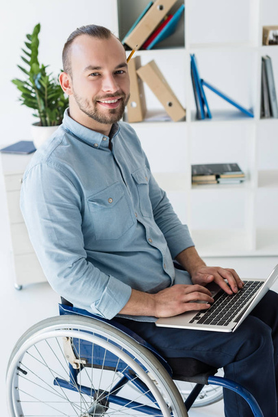 homem de negócios em cadeira de rodas usando laptop
 - Foto, Imagem
