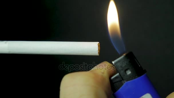 Handfeuerzeug Zigarettenanzündung Nahaufnahme. brennende Zigarette auf schwarzem Hintergrund. Zigarette Nahaufnahme auf schwarzem Hintergrund - Filmmaterial, Video