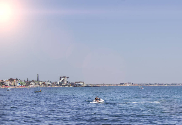 gente montando en motos acuáticas en el mar en un día soleado y cielos despejados
 - Foto, Imagen