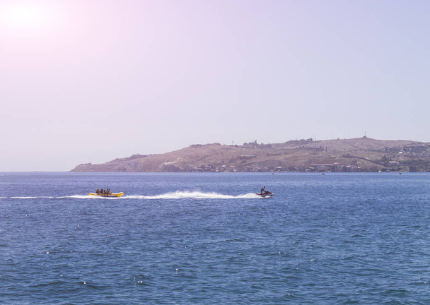 people riding on jet skis in the sea on a sunny day and clear skies - Photo, Image