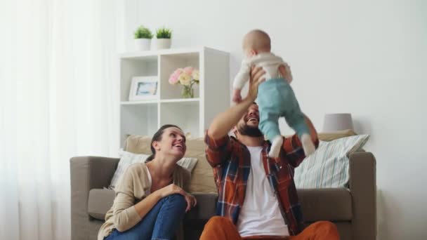 happy mother and father playing with baby at home - Záběry, video