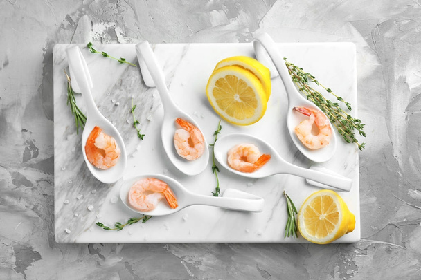 Spoons with delicious shrimps and lemon - Фото, изображение