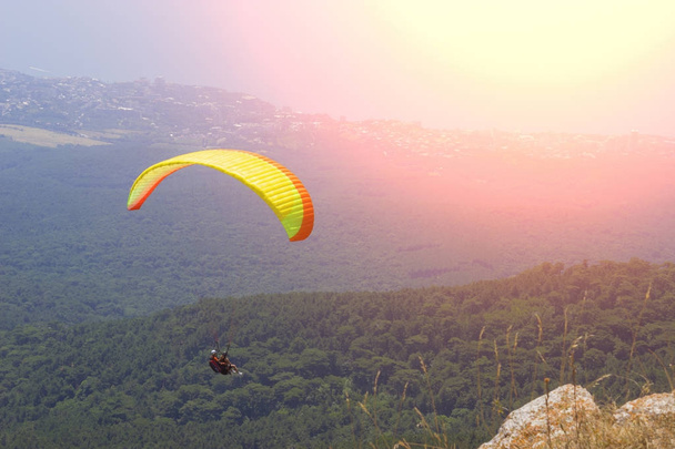 Sportman vliegt paraglider in de hemel. Paragliding sport gevaarlijke - Foto, afbeelding