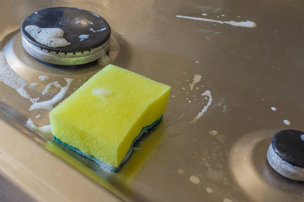 Detergent with foam and sponge on electric hob. For electric cooker applied for washing grease and rust - Photo, Image