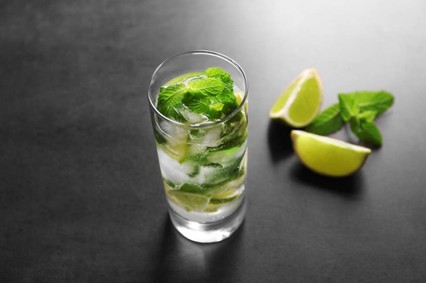 Glass of cocktail with lime and mint on grey background - Fotó, kép