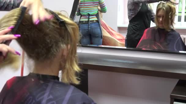 Cabeleireiros pentear cabelo cliente feminino na frente do espelho. Mudança de foco. 4K
 - Filmagem, Vídeo