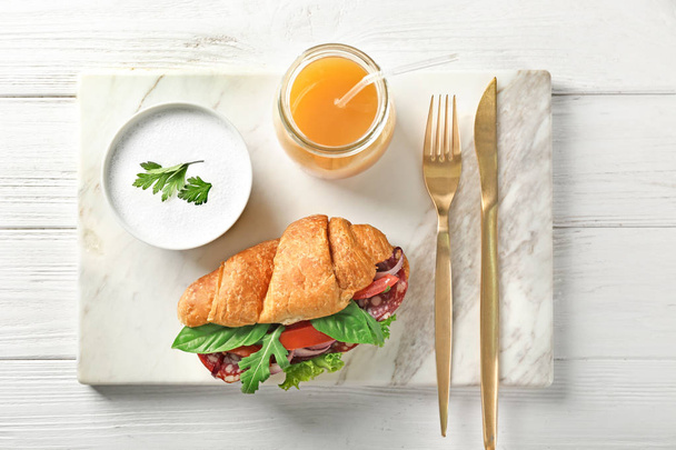 Delicious croissant sandwich with sausage and vegetables - Foto, imagen